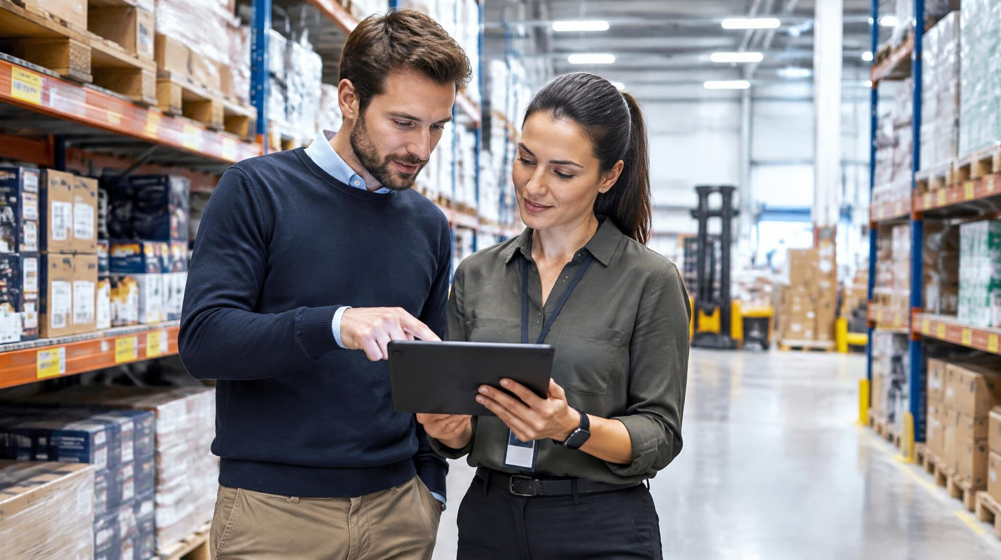 Retail operations team reviewing inventory data on a tablet in a warehouse